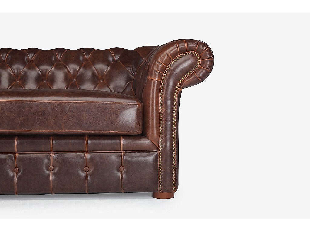 Coutures cloutées et accoudoirs du canapé chesterfield CLOTAIRE marron chocolat